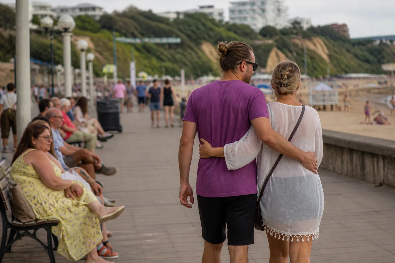 Two people talking beside Bournemouth beach and pier